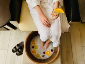 Warm coconut milk foot soak with a glass of champagne in hand